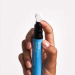 belif Aqua Bomb Depuffing Eye Gel 15ml – kühlendes Augengel mit Koffein, Hyaluronsäure & Niacinamid. Imagebild, Hand hält Eye Gel hoch.