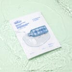 Dr. Belmeur Spot Care Intense Face Mask 30ml – beruhigende Tuchmaske mit Teebaumöl, Salicylsäure und Panthenol für unreine Haut. Abbildung Produkt liegt im Wasser.