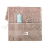 edel+white Flosserpik Power Spa – Der Champion der mobilen Mundduschen mit viel Power. Abbildung Produkt im Handtuch mit verschiedenen Aufsätzen.