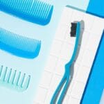 megasmile Loop toothbrush with activated charcoal bristles. Picture toothbrush blue in the bathroom. 