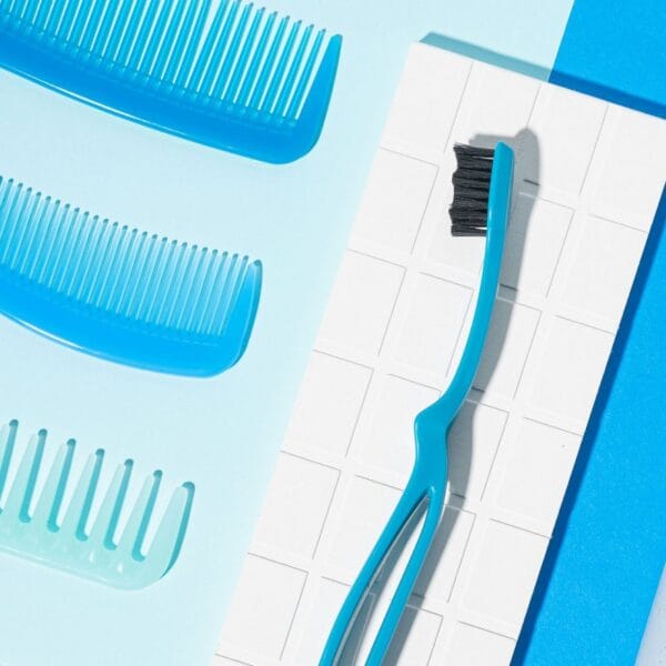 megasmile Loop toothbrush with activated charcoal bristles. Picture toothbrush blue in the bathroom. 