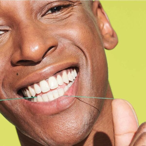 18230992 REACH POP Zahnseide Peppermint Floss – vegane, gewachste Zahnseide mit 384 Mikrofäden & nachhaltiger Verpackung, 50m, Pfefferminz Geschmack. Abbildung Zahnseide in Aktion.